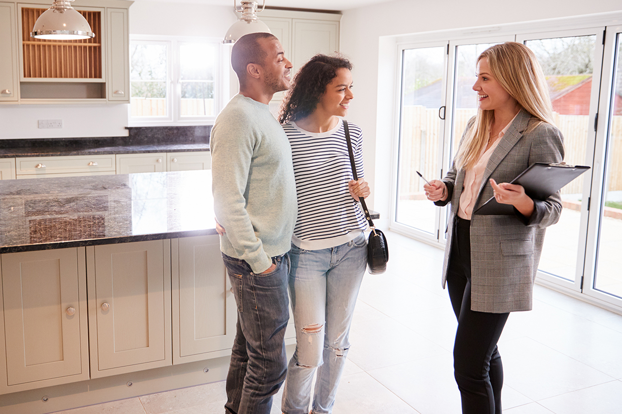 Young couple touring home with realtor