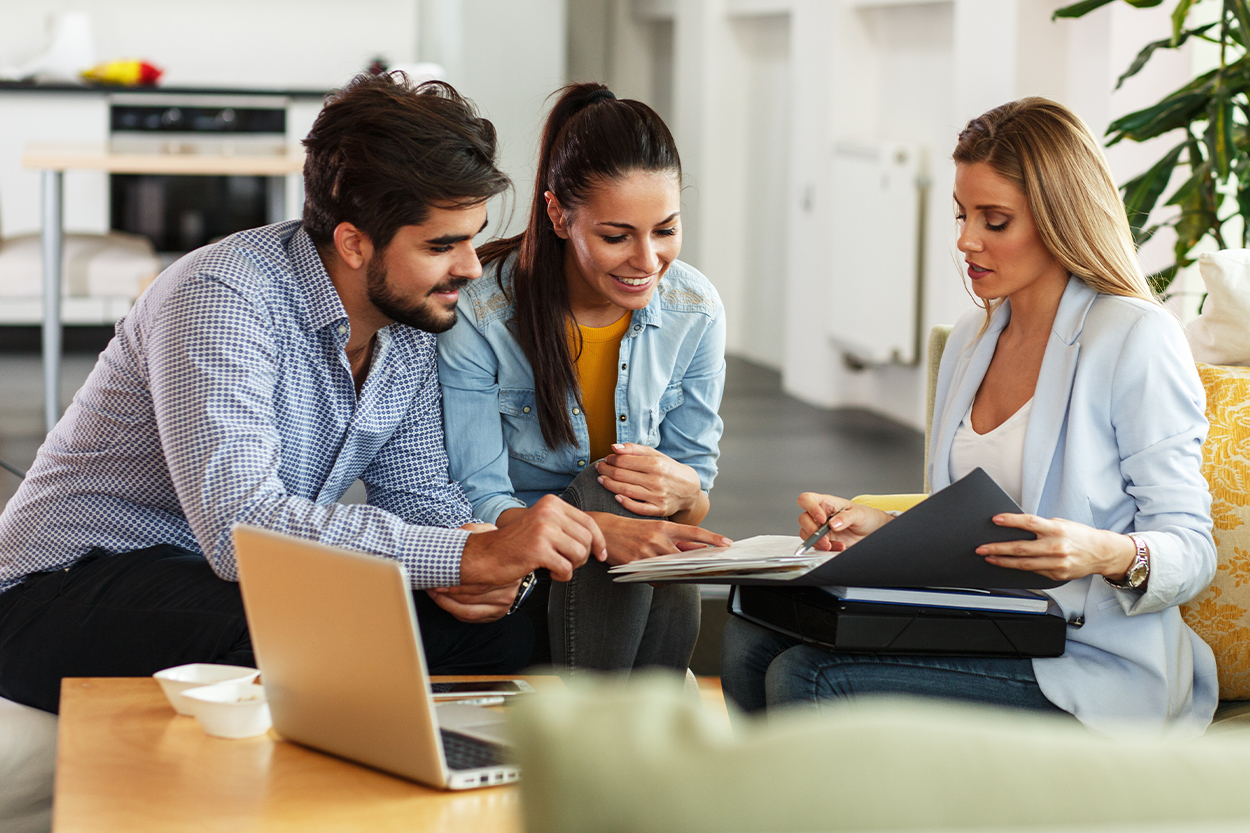 Young couple meet with realtor in living room