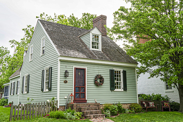 Small green house with trees in yard