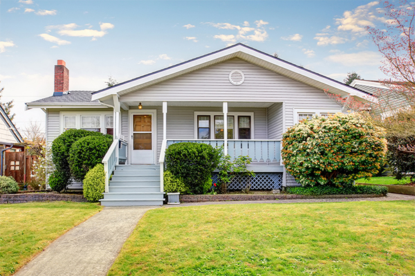 white house with front porch and shrubs