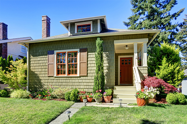 small green house with landscaped flower beds