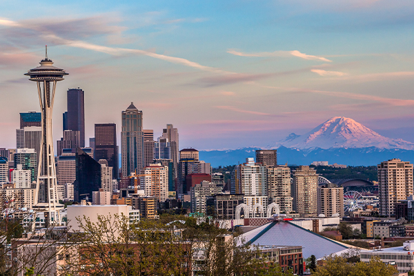 Skyline of Seattle with mountains in the background at sunset