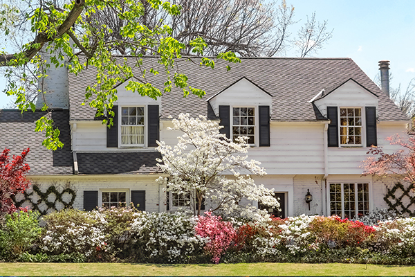 White house with flowers and shrubbery in yard