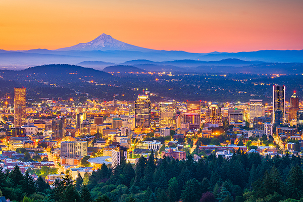 Skyline of Portland at sunset with mountains in the background