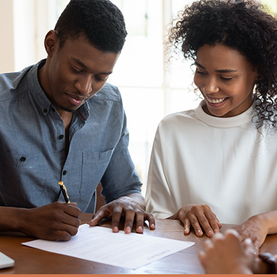 Young couple signing paperwork