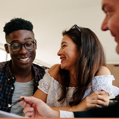 Young couple smiling talking with their realtor