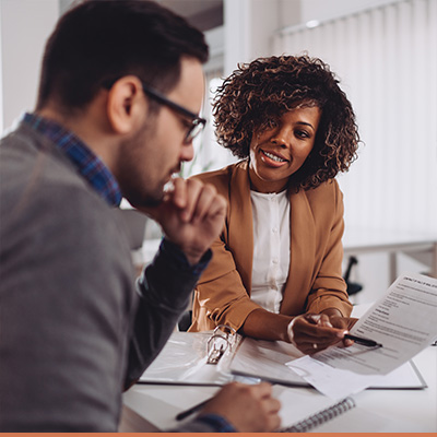 Man with business professional, reviewing paperwork