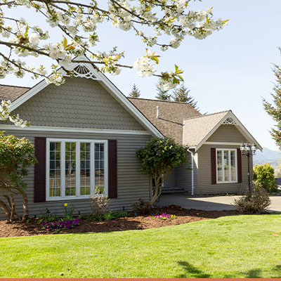 Exterior brown house with green yard and blue skies