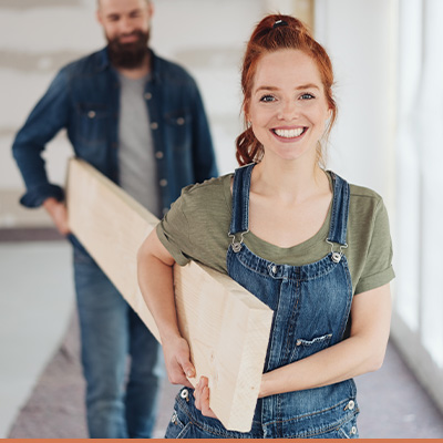 Young couple carrying hardwood during home renovation