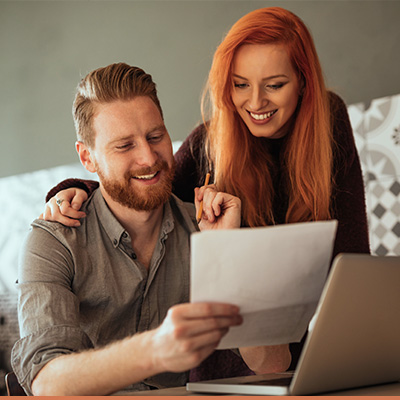 young couple smiling while reviewing paperwork