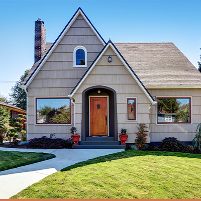 gray cottage with oak door and green grass