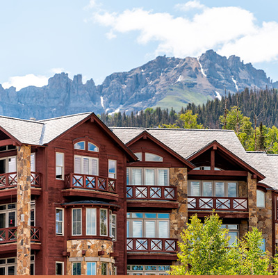 Wood and stone condos with mountains in the background