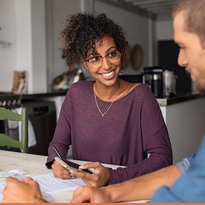 Young couple reviewing and discussing paperwork at table 