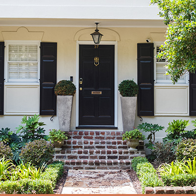 Southern front porch with brick steps and landscaped plants around