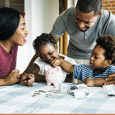 Young family saving their money in a piggy bank