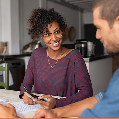 young man and women smiling while reviewing paperwork