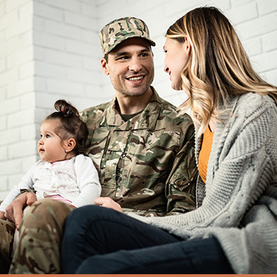 Young family with military father sitting on couch talking