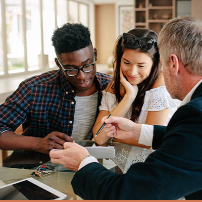 Young couple meeting with realtor learning information from paperwork