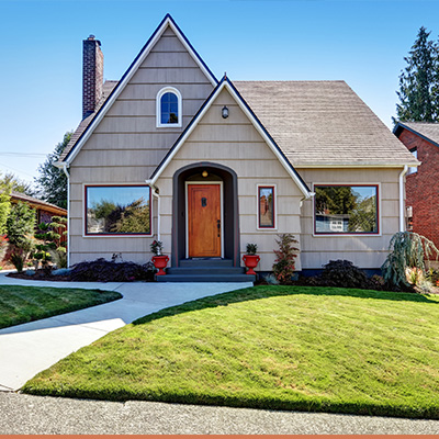 Exterior cottage style house with green yard and blue sky