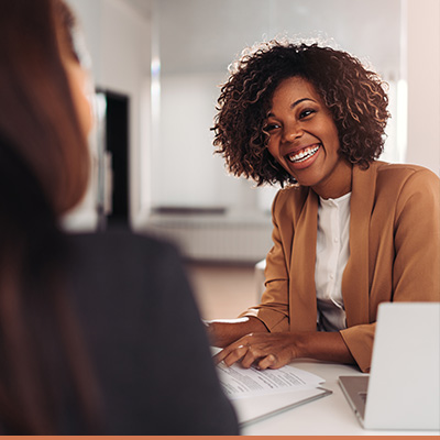 Realtor meeting with client smiling reviewing paperwork