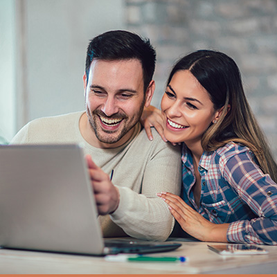 Couple smiling looking at laptop