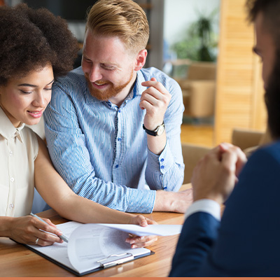 Young couple reviewing finance options with realtor