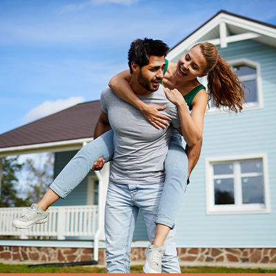 Young happy couple in front of their new house