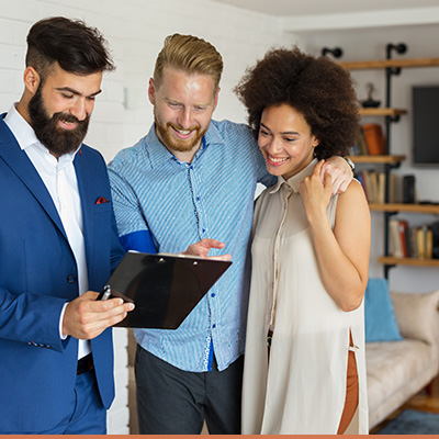 Young couple reviewing paperwork with realtor