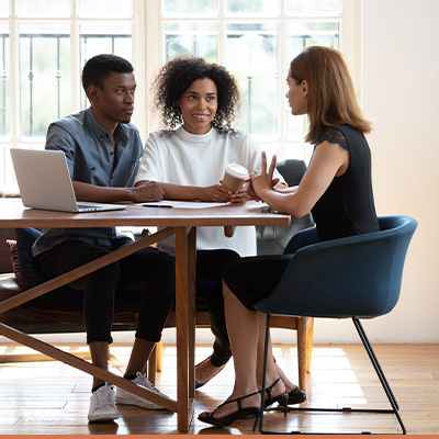 Young couple meeting with realtor at dining room table