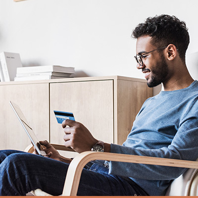 Young man smiling sitting in chair reviewing his credit