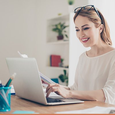 Young teacher reviewing homework on her laptop