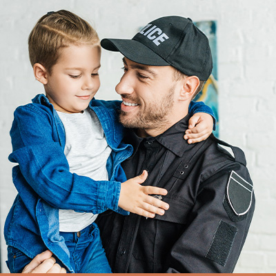 Young police father holding his son smiling