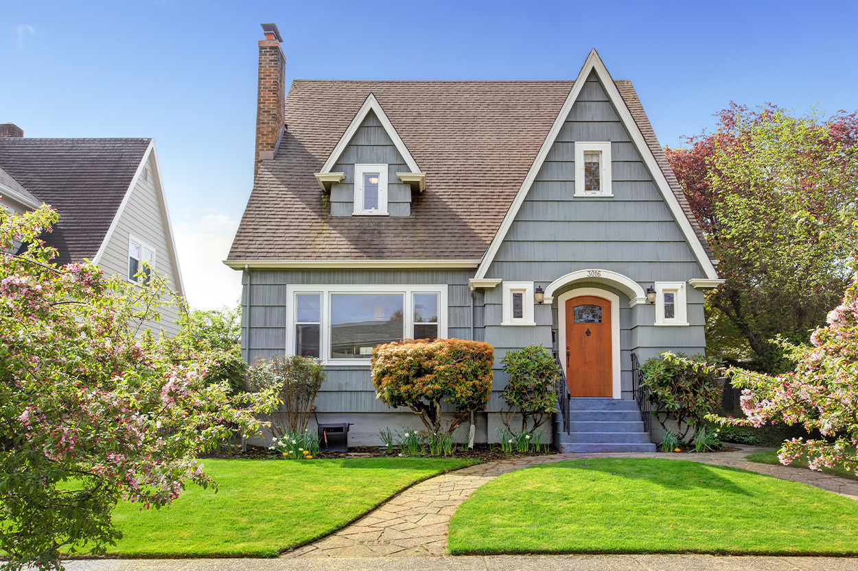 Cottage style home with green grass and blue skies