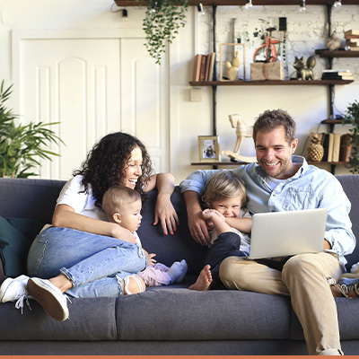 Family on couch looking at laptop