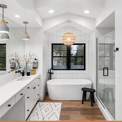 Renovated bathroom with white countertops and black hardware