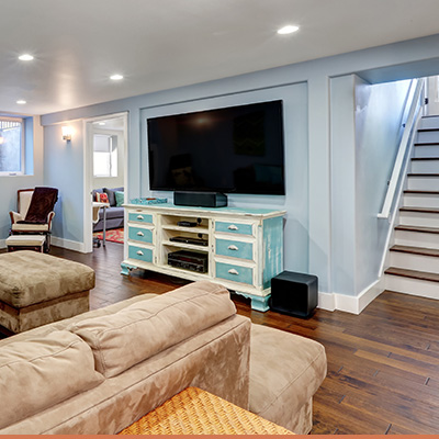 Finished modern basement with light blue walls and big screen television