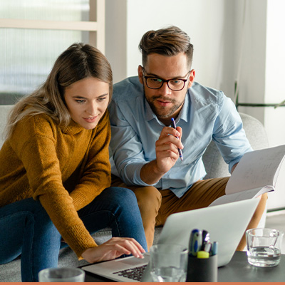 Young couple researching on laptop in livingroom