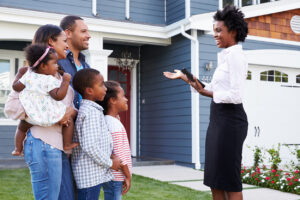 Realtor speaking with her clients outside of house