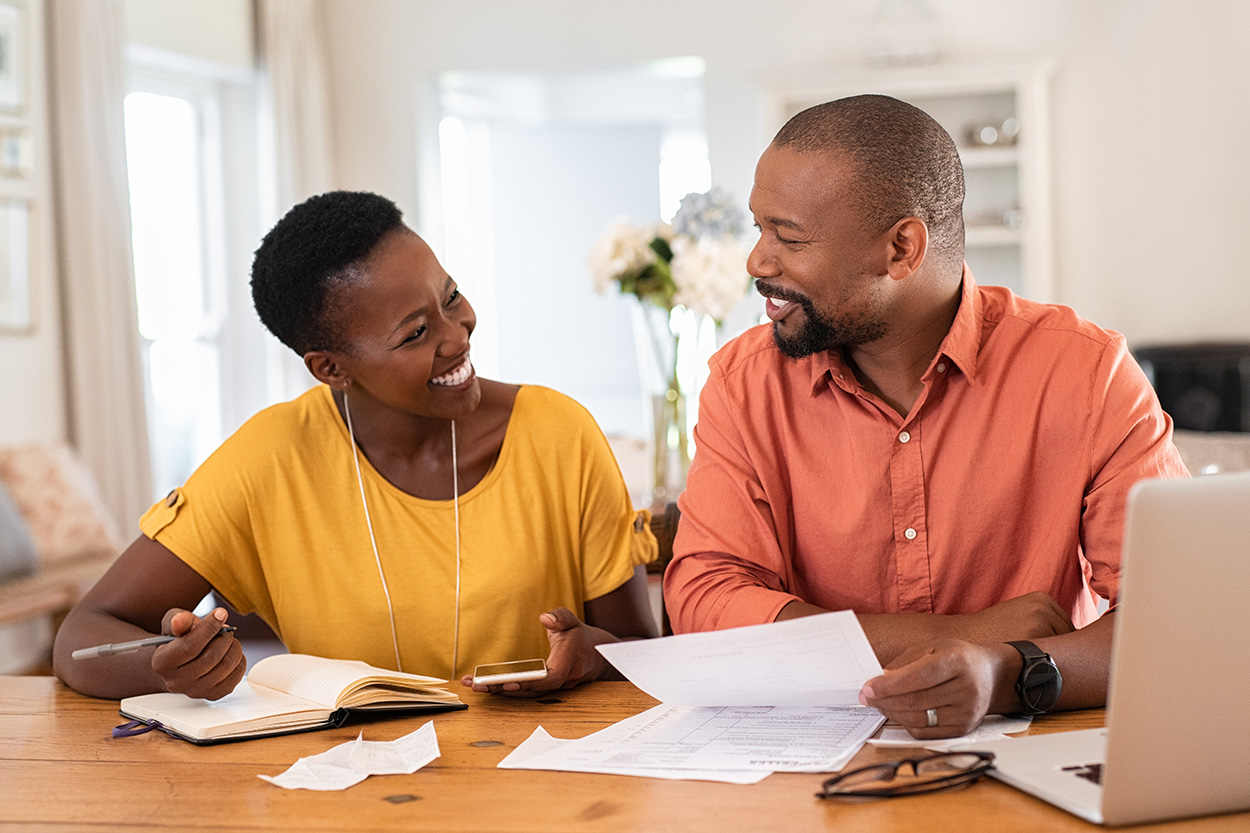 Couple at table reviewing paperwork smiling