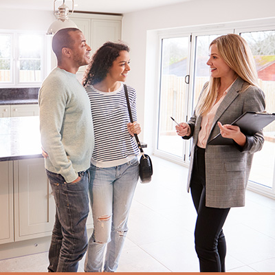 Couple meeting with real estate agent at house showing