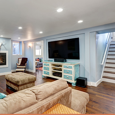 Interior finished basement with light blue walls and wood staircase