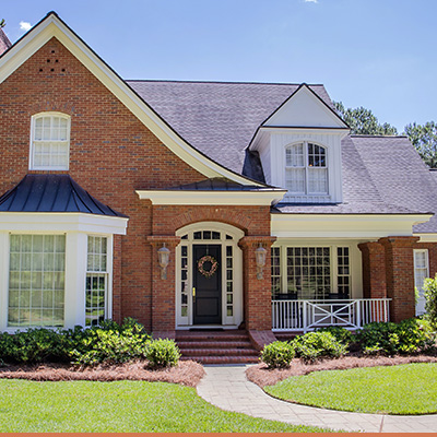 Brick cottage style home with landscaping