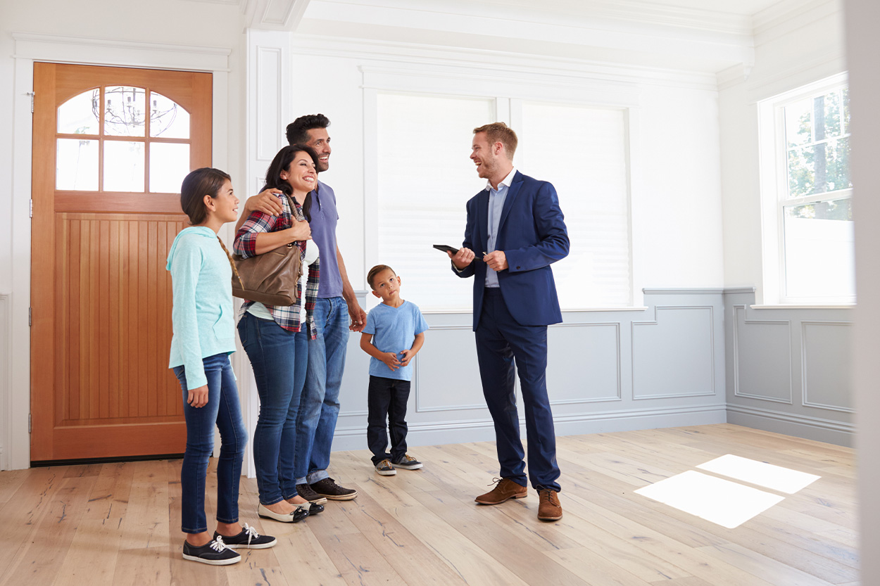 Family touring an empty home with realtor