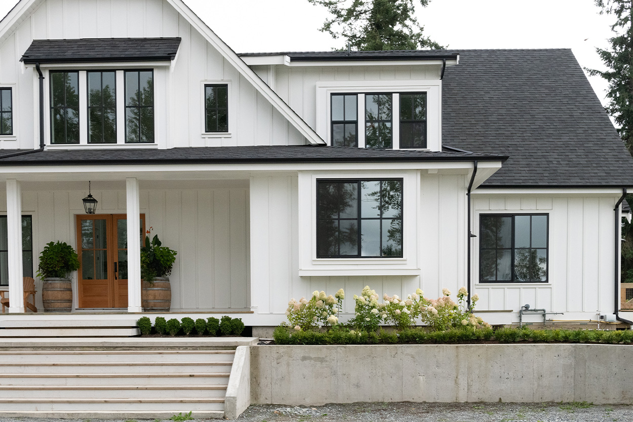 Exterior of new house with black trim and white siding