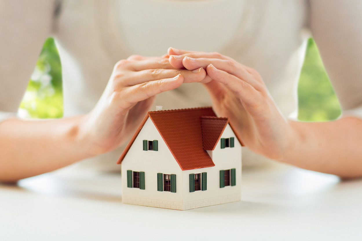 Woman covering house with hands